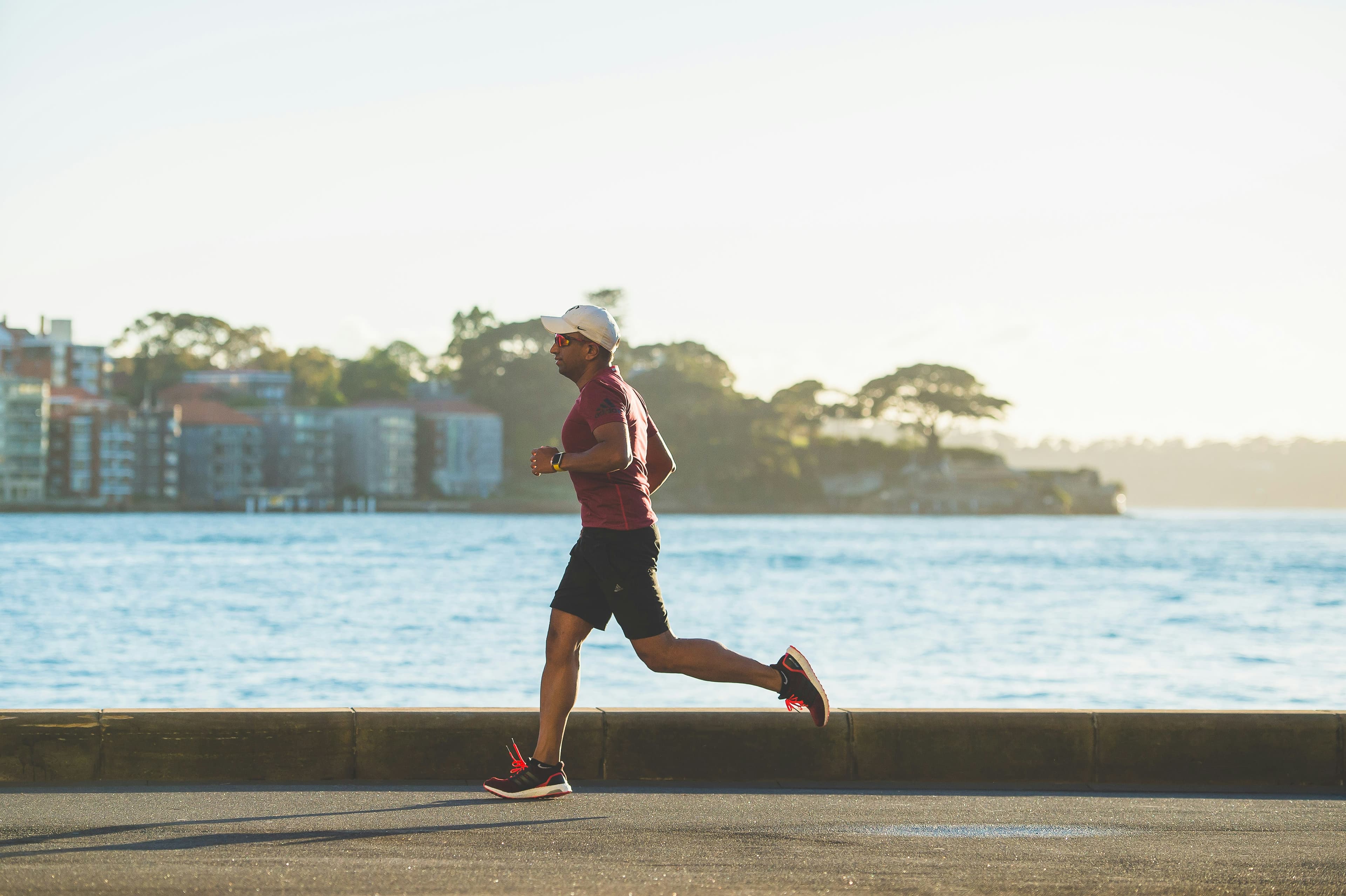 Man running along waterfront representing performance and body composition